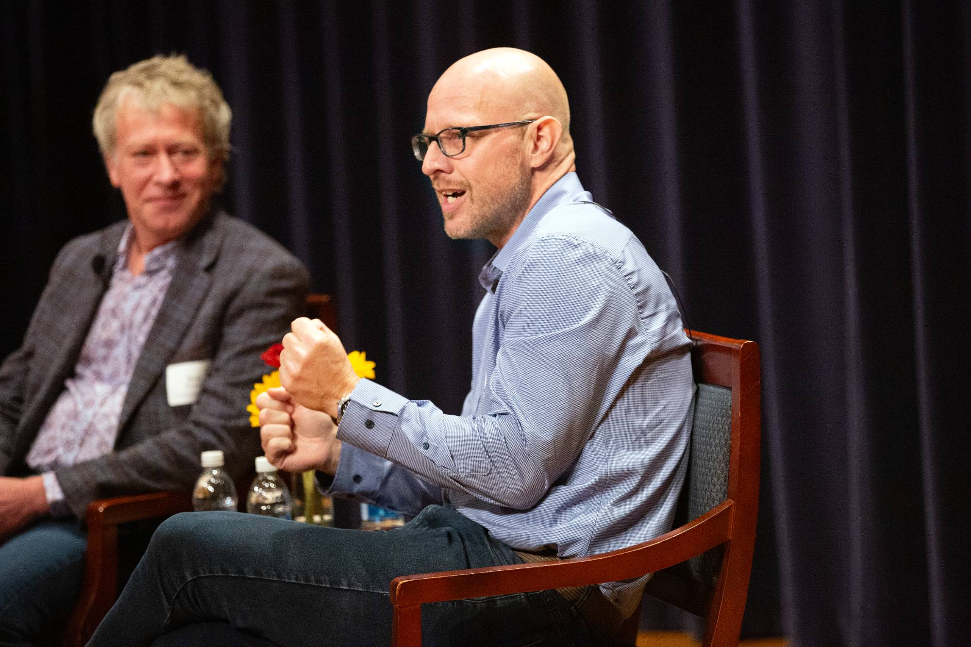 two people sitting on stage